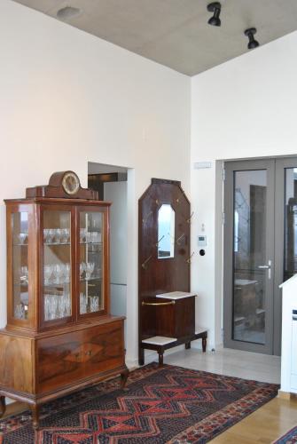 a living room with a wooden cabinet and a clock at LEONIDIONHOUSES - The Lykoskufi Villas in Tiros