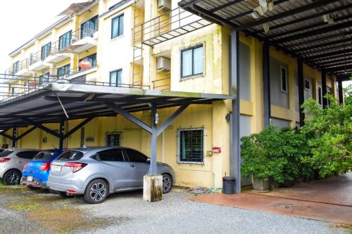 two cars parked in a parking lot in front of a building at Chivapuri Trat in Trat