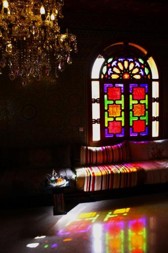 a room with a couch and a stained glass window at Riad Noumidya in Fès