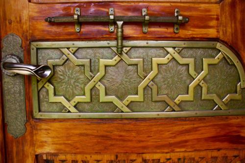 a metal door with a design on it at Riad Noumidya in Fès