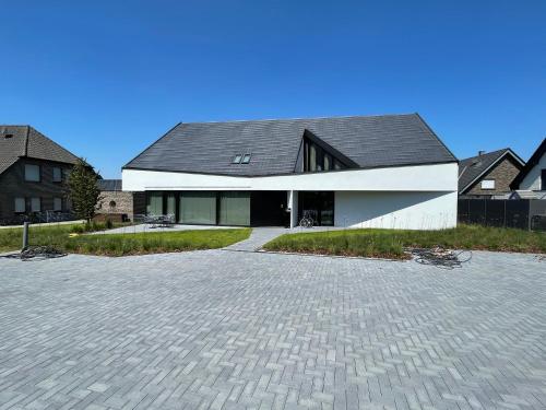 une grande maison blanche avec un toit noir dans l'établissement Ferienwohnung Zwischenhoch, à Kranenburg