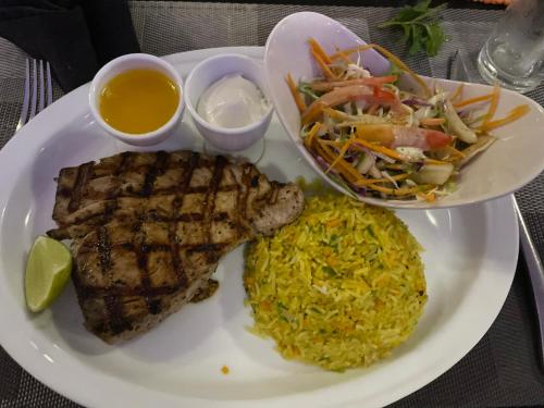 a plate of food with meat and rice and a salad at Samalanka Boutique Hotel in Habaraduwa
