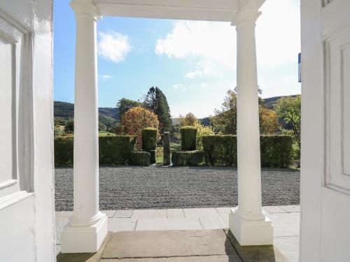 a view of a garden through an archway at Llwynderw Hall in Llanwrtyd Wells