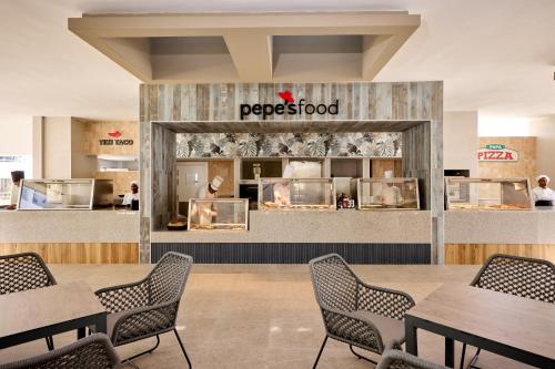 a restaurant with tables and chairs in a cafeteria at Riu Palace Bavaro - All Inclusive in Punta Cana