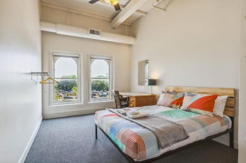 a bedroom with a bed and a desk and windows at The Victor 3 - Cleveland's Urban Lodge in Cleveland