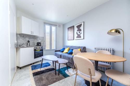 un salon avec un canapé bleu et une table dans l'établissement Appartement Gagny centre proche RER, à Gagny