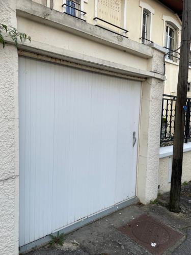 a white garage door on the side of a building at Havre de paix proche paris in Savigny-sur-Orge