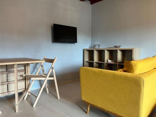 un salon avec un canapé, une table et une télévision dans l'établissement Le Studio des Marmottons, cœur de village, à Bonne