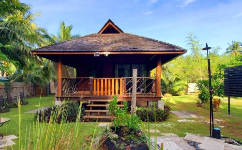a gazebo with a porch in a garden at Fare Haumaru in Teavaro