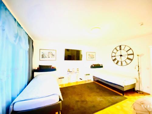 a bedroom with two beds and a clock on the wall at Welcome to Messe!-Two-Bedroom Apartment&Balcony in Hannover