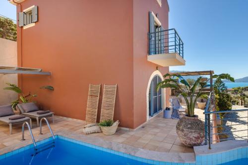 a house with a swimming pool next to a building at Braunis Horio Villas in Asos