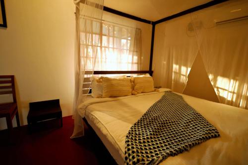 a bedroom with a bed with a black and white bedspread at Temple Garden Palolem in Canacona