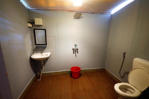a small bathroom with a toilet and a sink at Temple Garden Palolem in Canacona