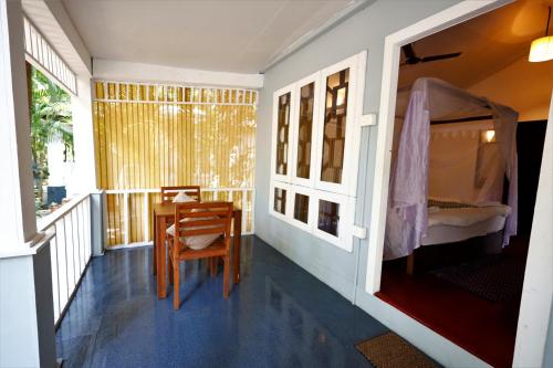 a room with a table and a bed on a balcony at Temple Garden Palolem in Canacona