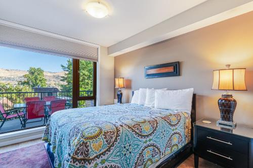 Un dormitorio con una cama y un balcón. en Chelan Resort Suites Sunny Livin 111, en Chelan