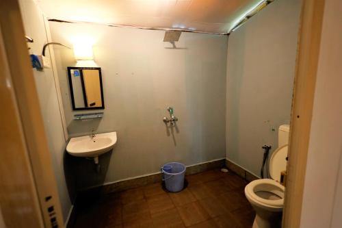 a small bathroom with a sink and a toilet at Temple Garden Palolem in Canacona