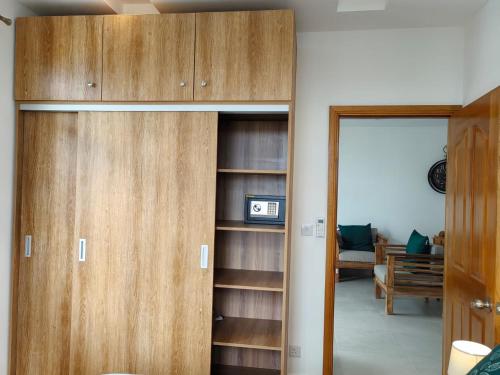 a closet with wooden doors and a living room at Luxury Seaview Apartment Flic en Flac CFF07 in Flic-en-Flac