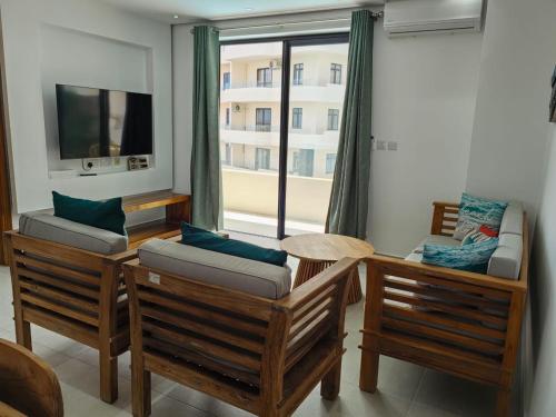 a living room with two chairs and a tv at Luxury Seaview Apartment Flic en Flac CFF07 in Flic-en-Flac