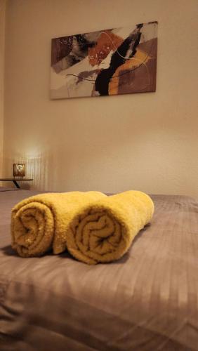 a yellow towel sitting on top of a bed at City Park Apartments in Pristina