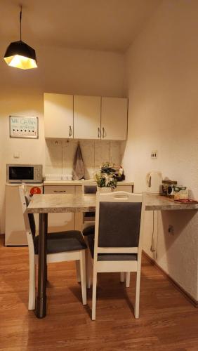 a kitchen with a table and chairs in a room at City Park Apartments in Pristina