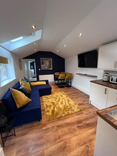 ein Wohnzimmer mit einer blauen Couch und einer Küche in der Unterkunft Waterside Cottage in Preston