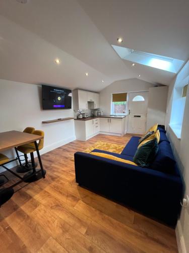 a living room with a blue couch and a table at Waterside Cottage in Preston