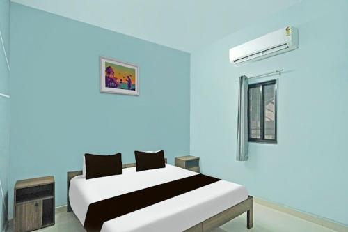 ein blaues Zimmer mit einem Bett und einem Fenster in der Unterkunft Hotel Nova in Raipur
