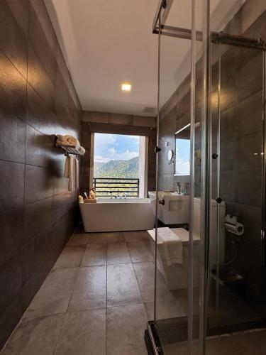 a bathroom with a shower and a tub and a sink at فندق إكليل الجبل in Ash Shafa