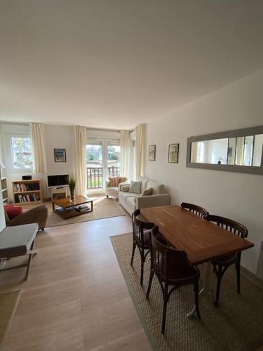 un grand salon avec une table et des chaises dans l'établissement Charmant appartement en bord de mer, à Cabourg