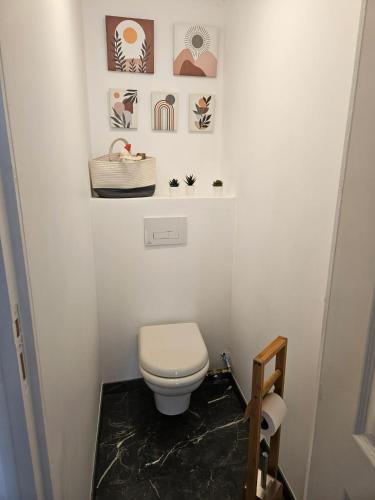 d'une petite salle de bains avec des toilettes et des photos. dans l'établissement Maison confortable à Saint-André-les-Vergers 40 m², jardin, à Saint-André-les-Vergers