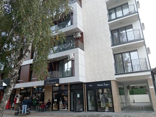 a building with a store in front of it at Adagio Apartmani in Vrnjačka Banja