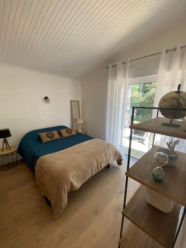 une chambre avec un lit et une grande fenêtre dans l'établissement Maison familiale dans les pins à 500m de la plage, à Saint-Jean-de-Monts