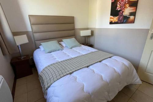 une chambre avec un grand lit blanc avec deux oreillers dans l'établissement VALBERG aux pieds des pistes et centre station, à Valberg