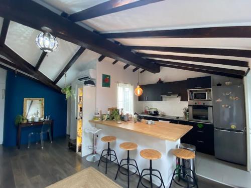 une cuisine avec un comptoir et des tabourets dans une pièce dans l'établissement Atypique appart plein centre, à Nice