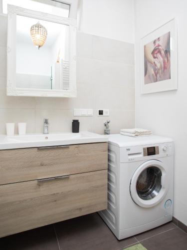 a bathroom with a washing machine and a sink at TheMarketFlat Schöne Wohnung im Stadtzentrum in Klagenfurt