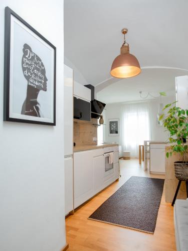 a kitchen with white cabinets and a black rug at TheMarketFlat Schöne Wohnung im Stadtzentrum in Klagenfurt