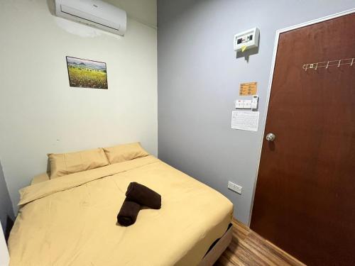 a bed in a room with a black object on it at Afie Roomstay KLIA Airport Transit in Sepang