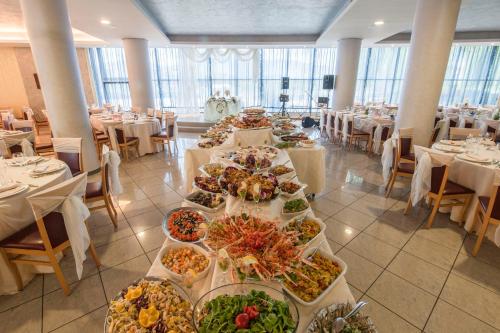a banquet hall with many plates of food on tables at Hotel Le Ginestre in Roccacasale