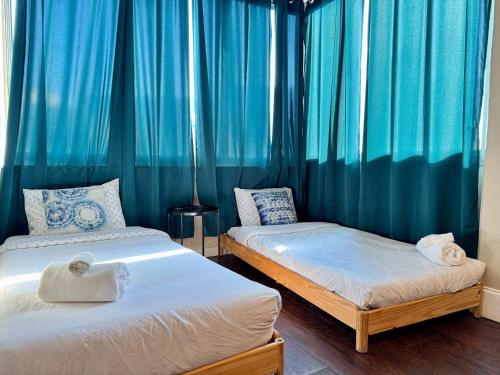 two beds in a room with blue curtains at Styled Downtown condo City View Onsite Parking LM404 in Atlanta