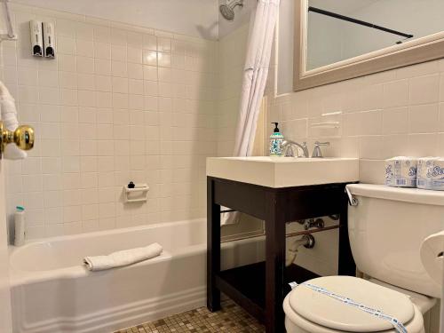a bathroom with a sink and a toilet and a tub at Styled Downtown condo City View Onsite Parking LM404 in Atlanta