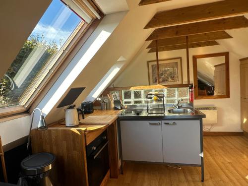 a kitchen with a sink and a large window at Annexe Lodge cottage in Drymen in Drymen