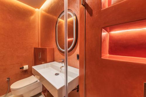 a bathroom with a white sink and a toilet at TAJ CHEFCHAOUEN Luxury Hotel and Spa in Chefchaouen
