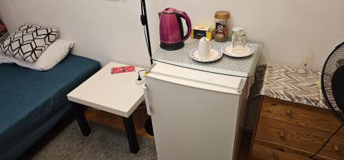 une petite cuisine avec un réfrigérateur et une table dans l'établissement Oddzielny pokój we wspólnym mieszkaniu, à Varsovie