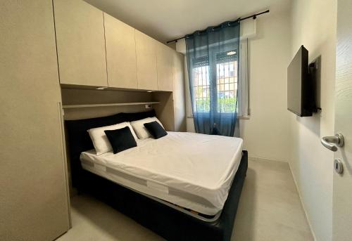 a bedroom with a bed with white sheets and pillows at Appartamento Conchiglia-Immobili e Soluzioni Rent in Lido Adriano