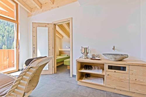 a bathroom with a sink and a vanity with a mirror at Hotel Steinrösl in San Cassiano