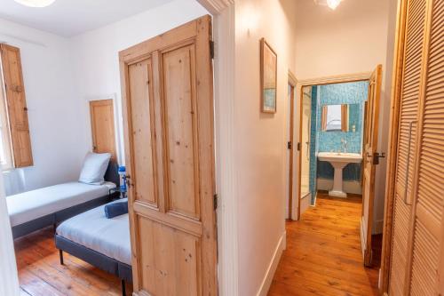 - un couloir avec une porte menant à une chambre dotée d'un lit et d'un lavabo dans l'établissement Le Lafayette-Capitole-Ascenseur -, à Toulouse