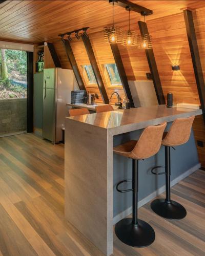 a kitchen with a island in a tiny house at Rosa Cabana de Canela in Canela