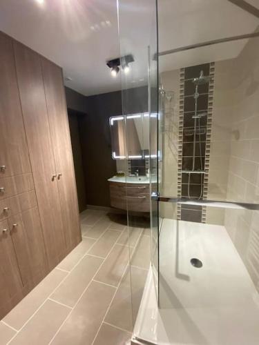 une salle de bain avec une douche en verre et un lavabo dans l'établissement Ravissante maison en bord de mer, à Dives-sur-Mer