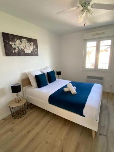 une chambre avec un grand lit avec des oreillers bleus et blancs dans l'établissement Ravissante maison en bord de mer, à Dives-sur-Mer