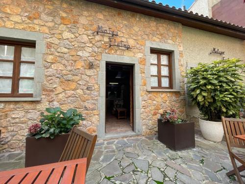 a stone house with two benches and a door at CAN LLORENÇ in Prades